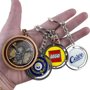 Hand holding a promotional custom keychain with a company logo at a trade show booth